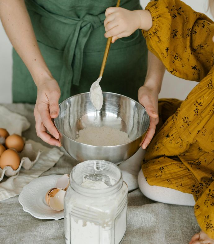 Mother and child mixing dough in a bowl, symbolizing family togetherness and home baking.